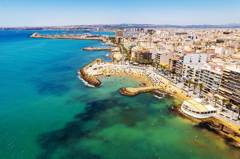 Aerial view of the Torrevieja seafront, its turquoise coves and its harbour in the background